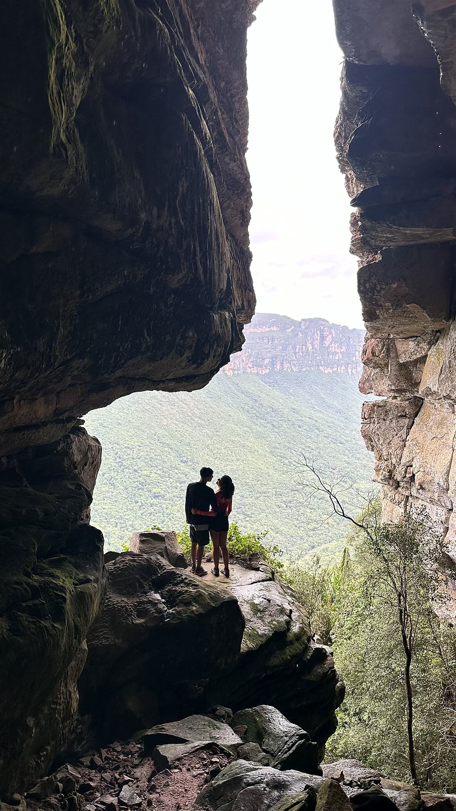 Casal na boca da gruta com vista para o vale